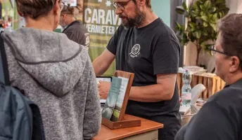 Lukas erklärt Besuchern am Messestand die Camping App