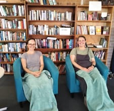 mums and bubs two mums in lounge with green towel on legs.jpg