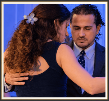 Tango embrace in blue stage light.png