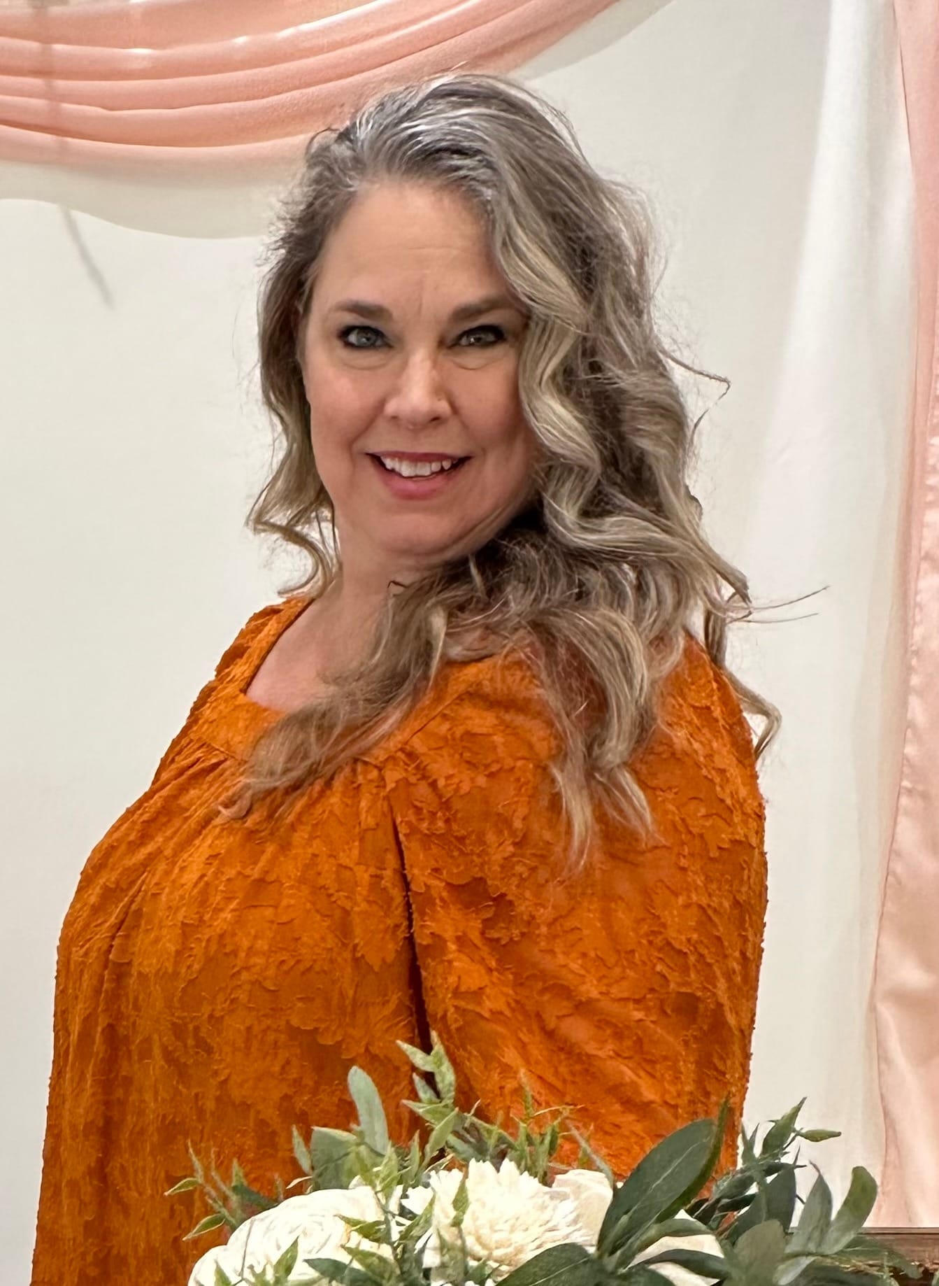 Photo os Jeanne Rosemann, the owner and designer of Rosewood Elegance, holding a wedding bouquet made of natural sola wood flowers
