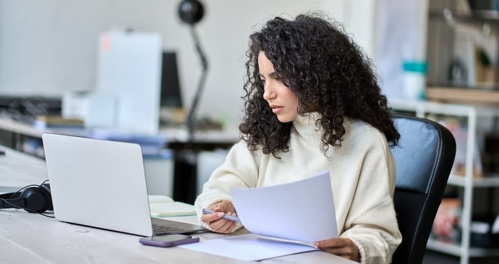 Woman reviewing estate planning documents at desk