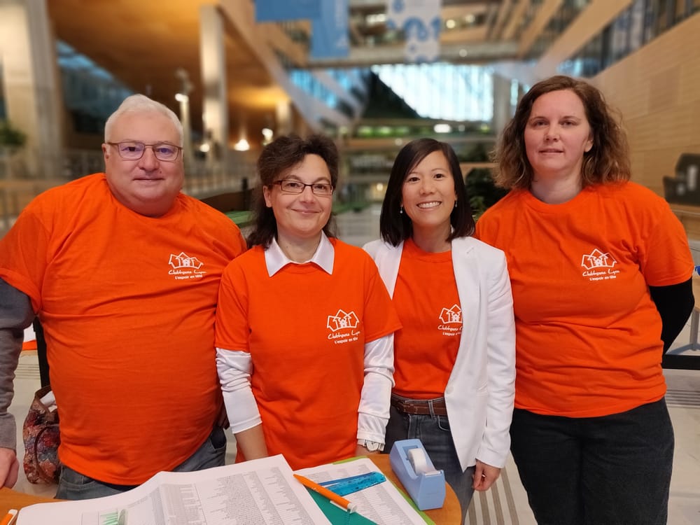 quatres-benevoles-en-t-shirt-orange-accueillants