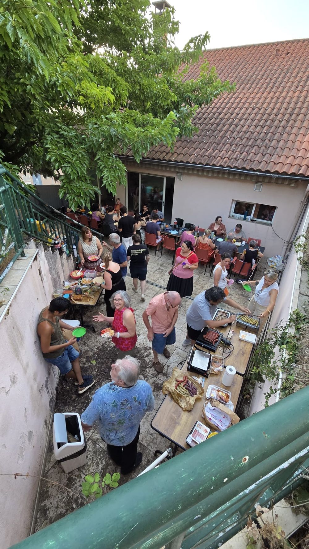 Tout le monde se rassemble dehors dans la cour autour des tables pour le début du buffet.