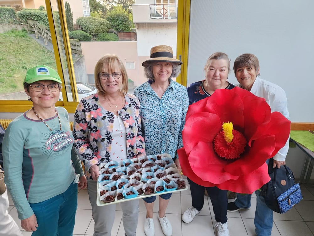 Laurence tenant une fleur rouge g&eacute;ante &agrave; c&ocirc;t&eacute; d'autres membres de l'association