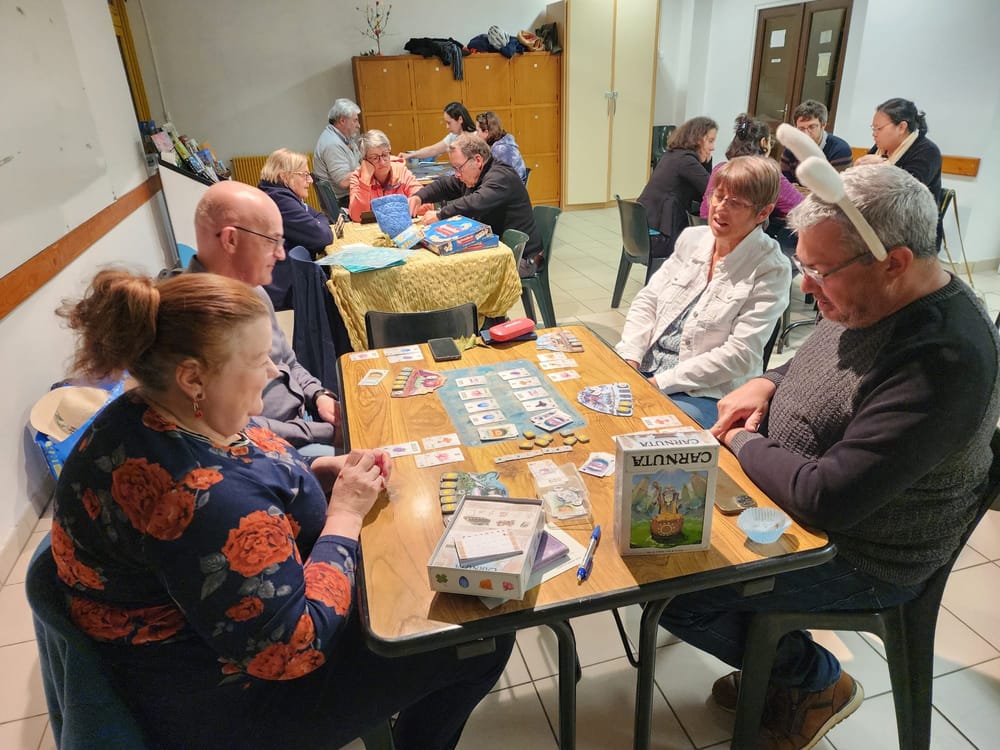 Fabrice et ses partenaires manipulant des runes autour de la bo&icirc;te du jeu Carnuta