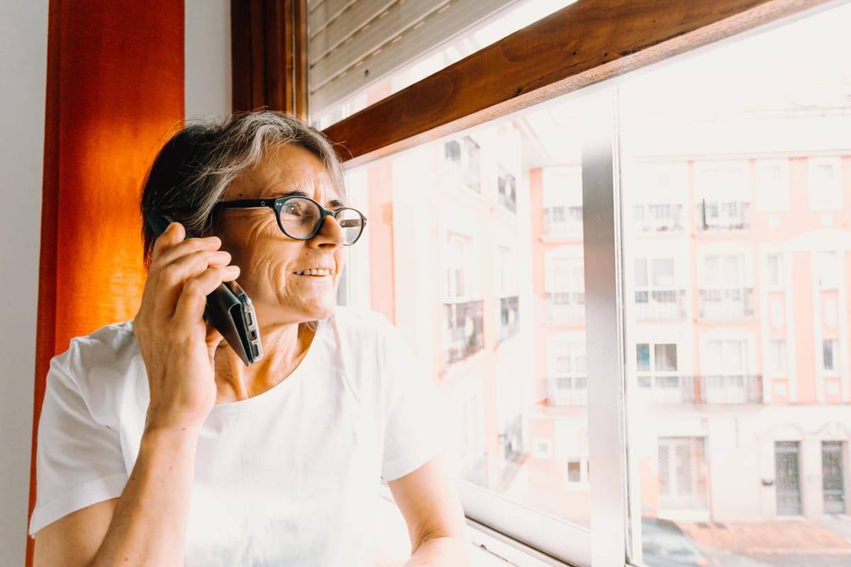 woman-in-glasses-on-the-phone-while-looking-out-a-window.jpg